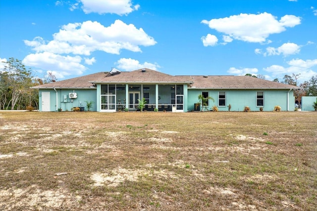 rear view of property with a yard and a sunroom