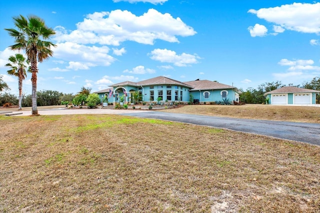 ranch-style house featuring a garage and a front lawn