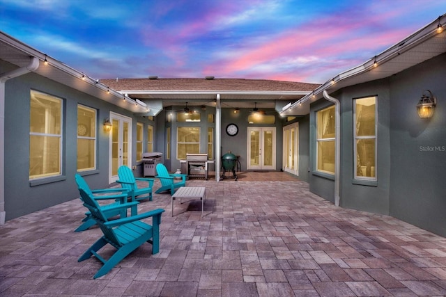 patio terrace at dusk with french doors and a grill