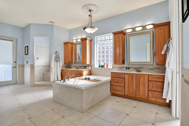 10030 Orchard Way, Spring Hill, FL 34608 - full bathroom with tile patterned floors, a bath, two vanities, and a walk in shower