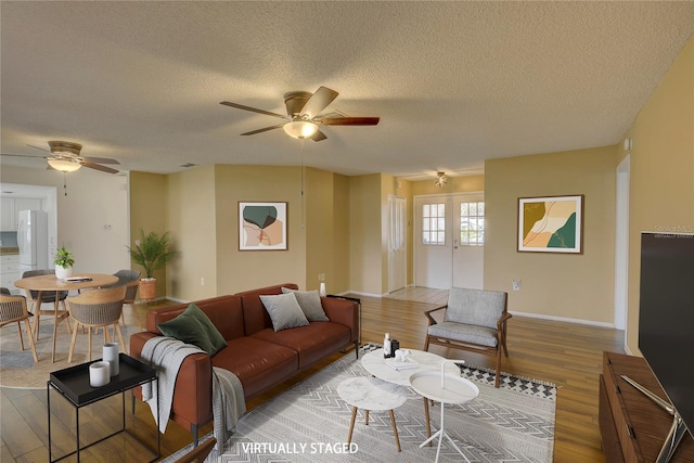 living room with hardwood / wood-style floors, a textured ceiling, and ceiling fan