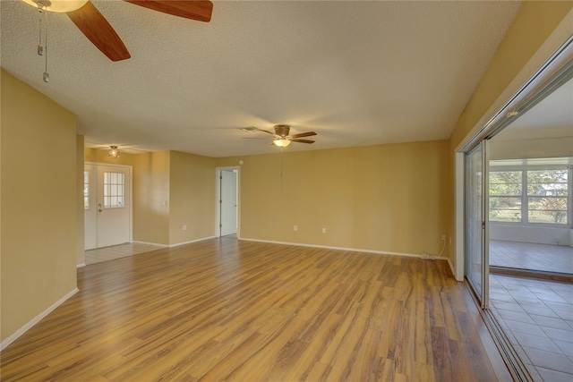 unfurnished room featuring ceiling fan, light hardwood / wood-style floors, and a textured ceiling