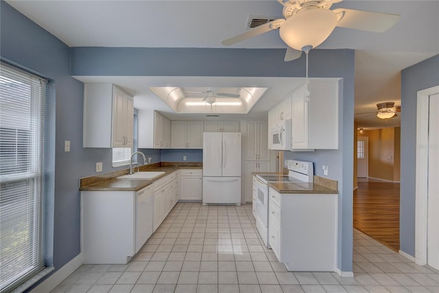 kitchen with sink, white cabinets, white appliances, and a tray ceiling