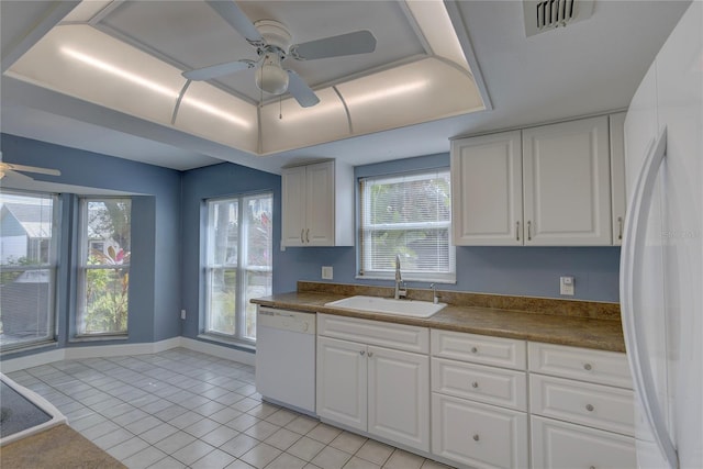 kitchen featuring sink, white cabinets, white appliances, and a tray ceiling