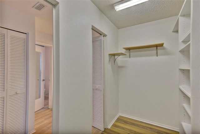 walk in closet with hardwood / wood-style floors