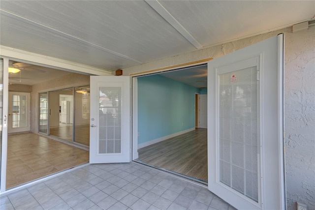 unfurnished sunroom featuring ceiling fan