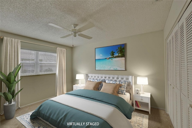 carpeted bedroom with ceiling fan, a closet, and a textured ceiling