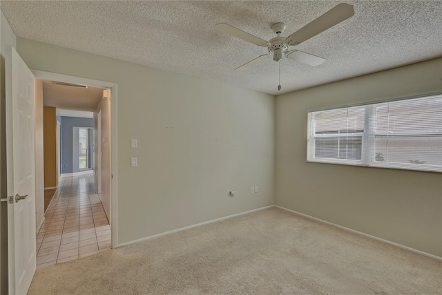 unfurnished room featuring ceiling fan, light carpet, and a textured ceiling