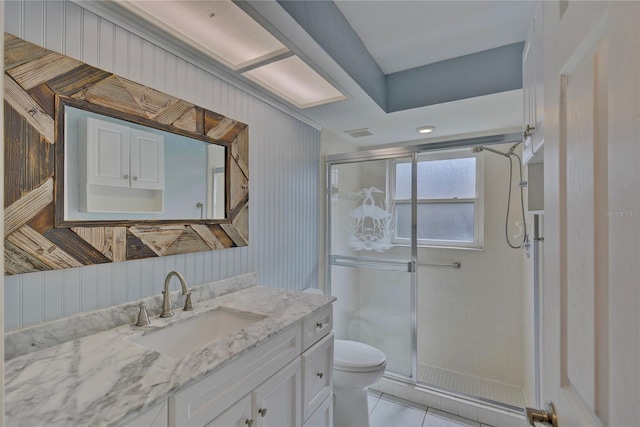 bathroom featuring a shower with door, vanity, tile patterned flooring, and toilet