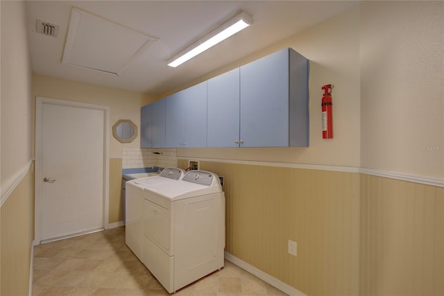 washroom with cabinets and washer and clothes dryer