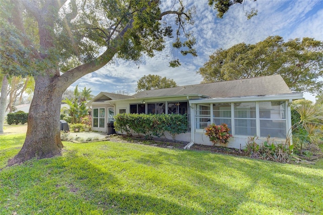 view of front of home with a sunroom and a front lawn