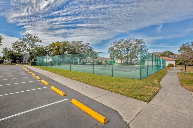 view of tennis court with a lawn