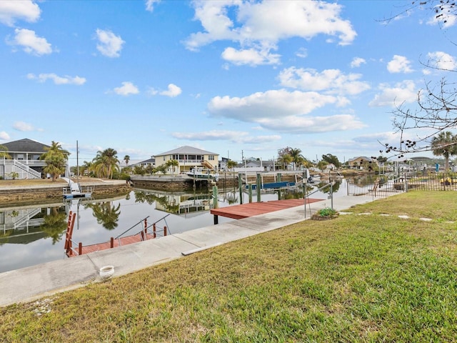 view of dock featuring a lawn and a water view