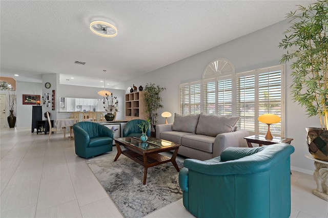 tiled living room featuring a textured ceiling