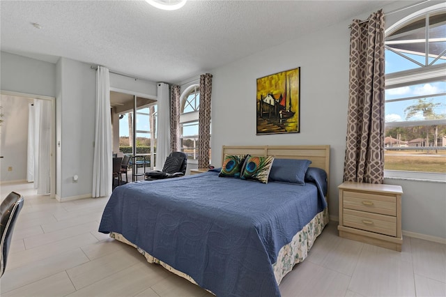 bedroom featuring access to outside and a textured ceiling