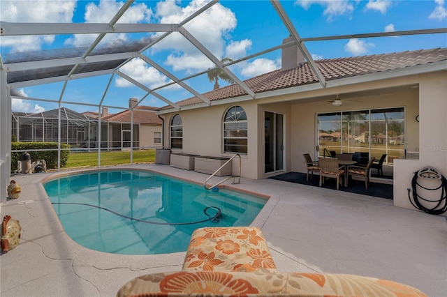 view of pool featuring ceiling fan, glass enclosure, and a patio area