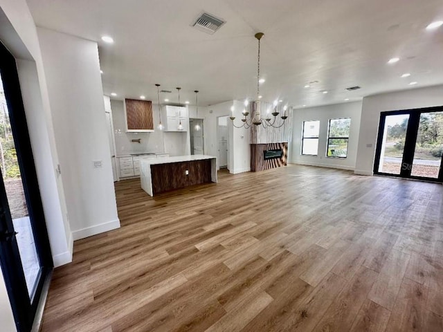 unfurnished living room with hardwood / wood-style flooring and an inviting chandelier