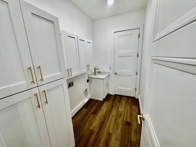 interior space featuring sink, cabinets, hookup for a washing machine, dark wood-type flooring, and hookup for an electric dryer