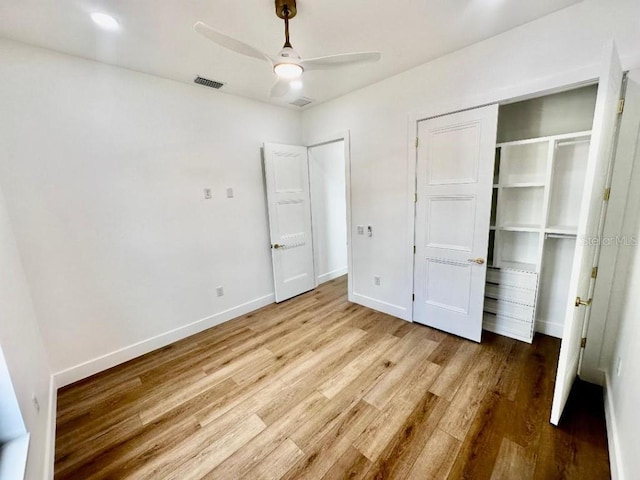 unfurnished bedroom with hardwood / wood-style flooring, a closet, and ceiling fan