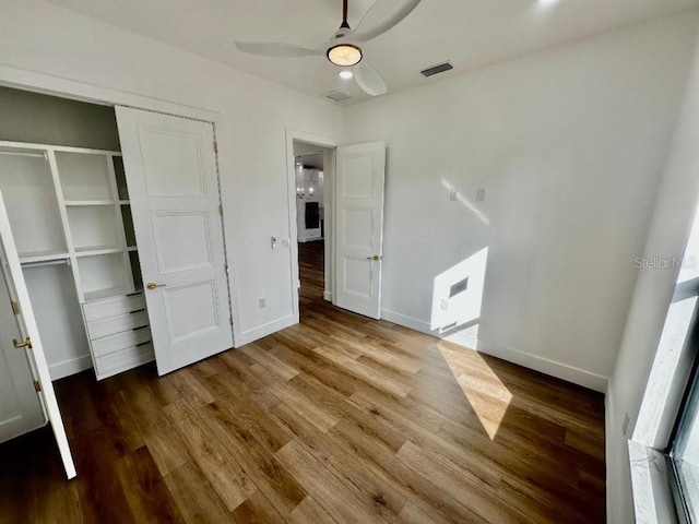 unfurnished bedroom with ceiling fan, hardwood / wood-style floors, and a closet