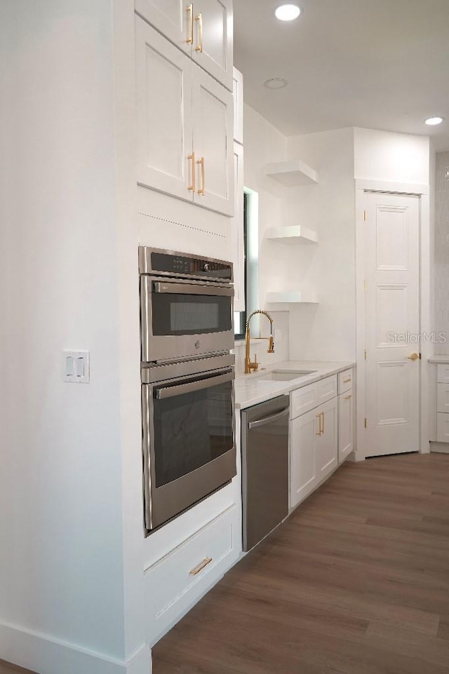 kitchen featuring open shelves, light countertops, appliances with stainless steel finishes, white cabinetry, and a sink