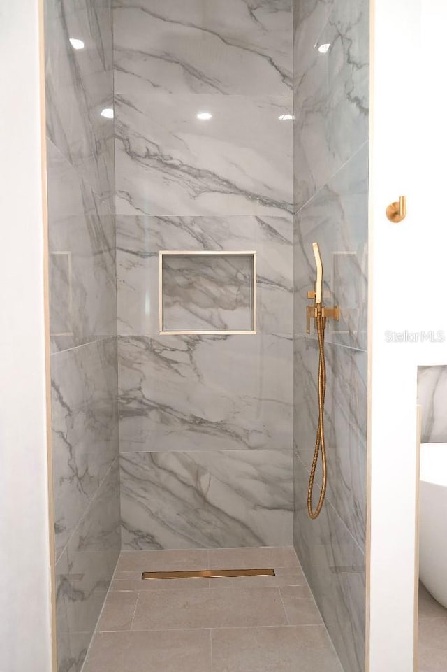 full bath with a freestanding tub and a marble finish shower