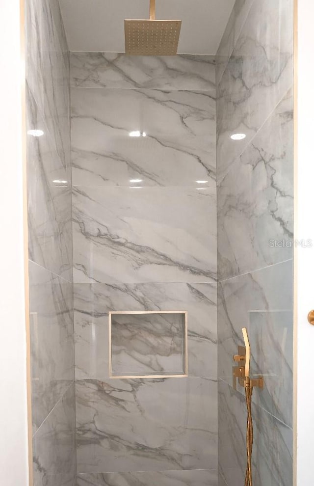 room details featuring a marble finish shower