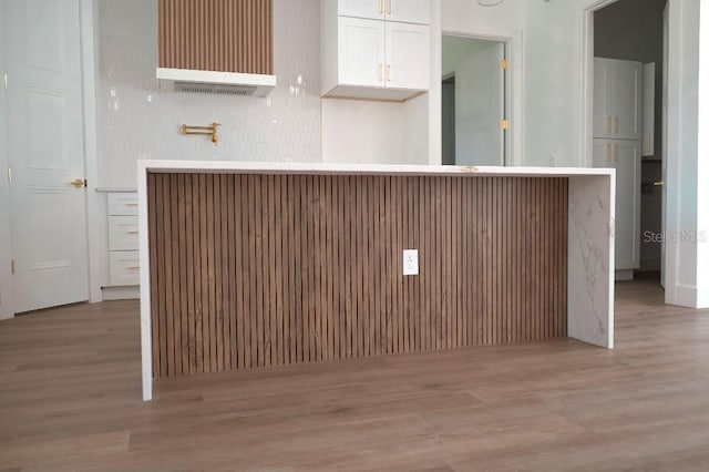 kitchen with white cabinets, light countertops, and light wood finished floors