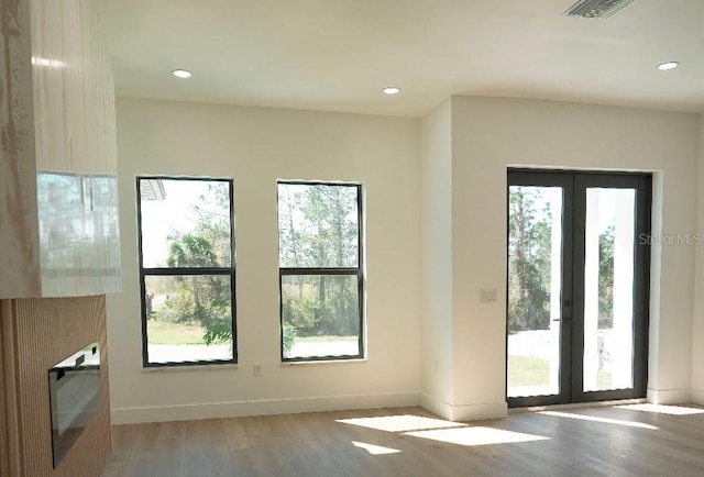 doorway featuring french doors, plenty of natural light, wood finished floors, and visible vents