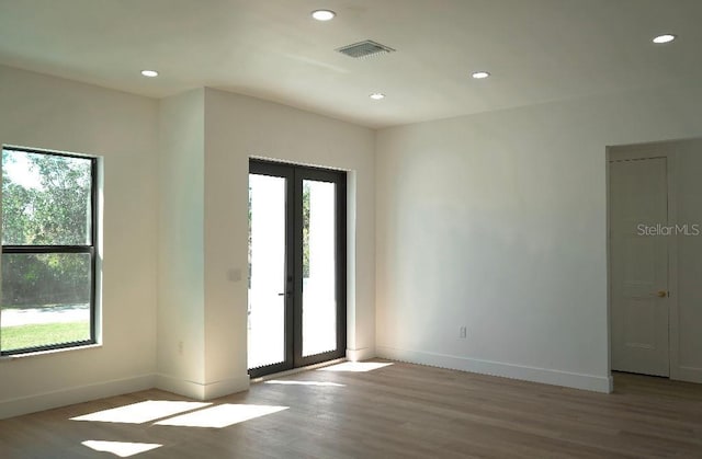 spare room featuring recessed lighting, visible vents, wood finished floors, and french doors