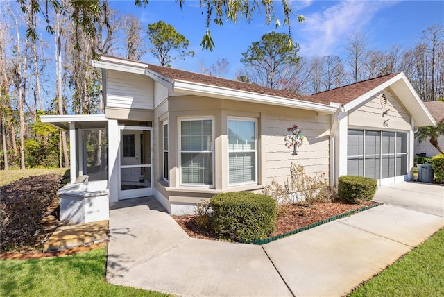 ranch-style home with a garage and a sunroom