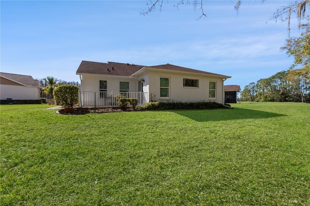 rear view of house featuring a yard