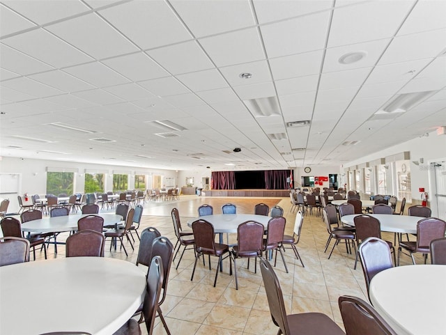 tiled dining space with a paneled ceiling