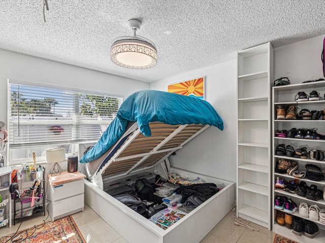 bedroom with light tile patterned floors and a textured ceiling