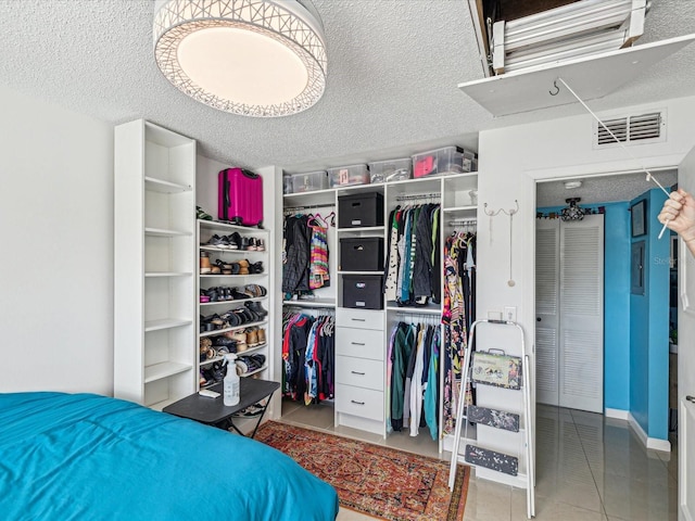 tiled bedroom featuring a textured ceiling and a closet