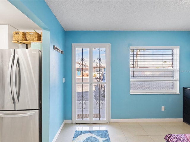 entryway featuring light tile patterned floors and a textured ceiling