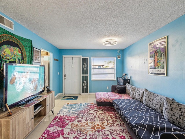 tiled living room featuring a textured ceiling