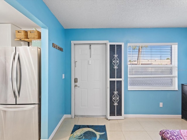 entrance foyer featuring light tile patterned floors and a textured ceiling