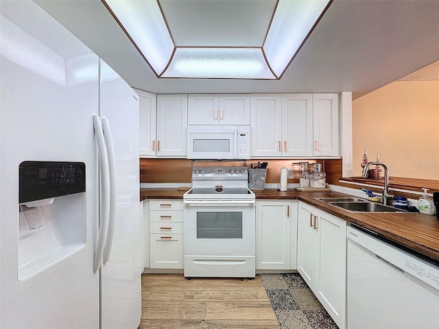 kitchen with wood counters, sink, white cabinets, light hardwood / wood-style floors, and white appliances