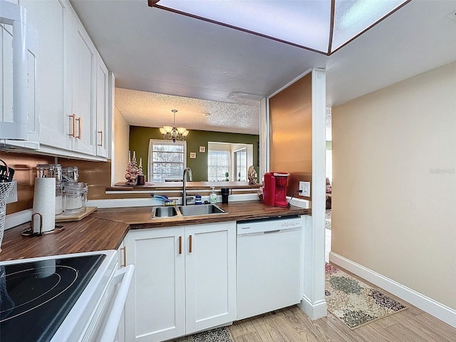 kitchen with white cabinetry, dishwasher, sink, and wooden counters