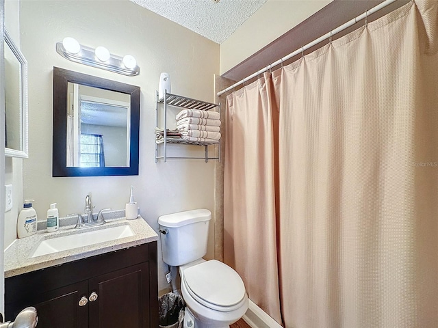 bathroom with vanity, toilet, and a textured ceiling