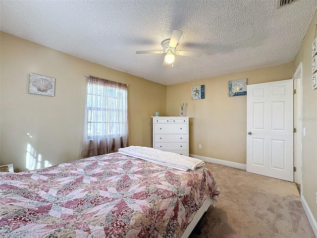 bedroom featuring ceiling fan, carpet floors, and a textured ceiling