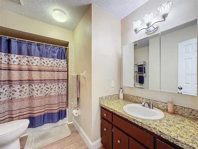 bathroom featuring walk in shower, toilet, a textured ceiling, vanity, and hardwood / wood-style flooring