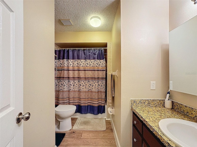 bathroom featuring hardwood / wood-style flooring, vanity, toilet, a textured ceiling, and a shower with shower curtain