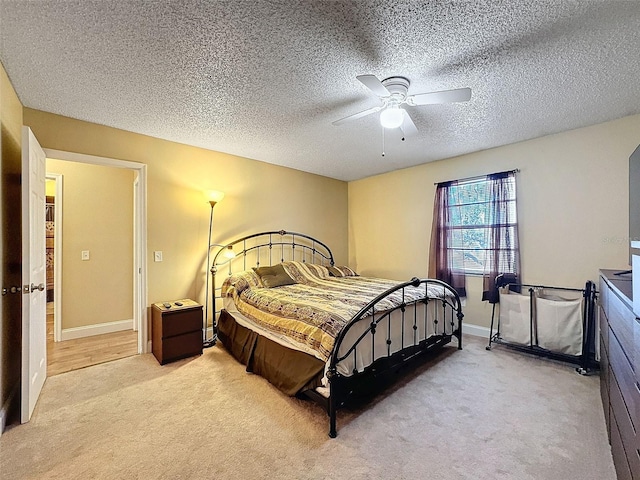 carpeted bedroom featuring a textured ceiling and ceiling fan