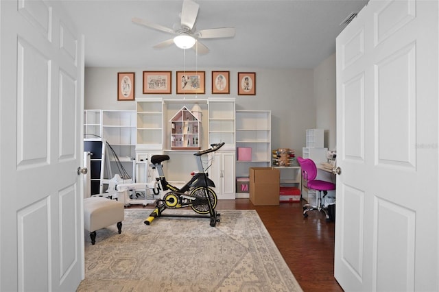 exercise room with ceiling fan and dark hardwood / wood-style floors