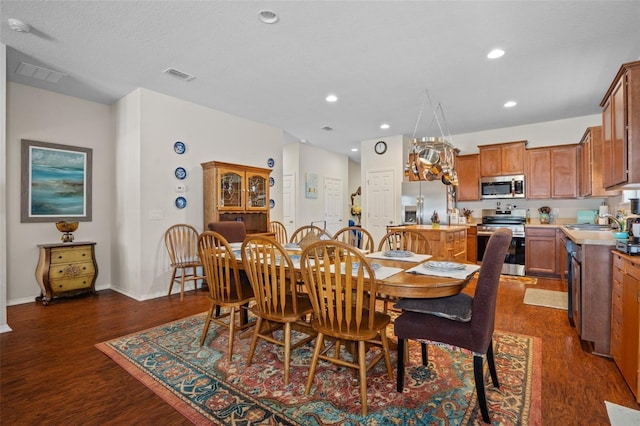 dining room with sink and dark hardwood / wood-style floors