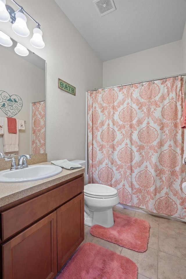 bathroom featuring vanity, tile patterned floors, and toilet