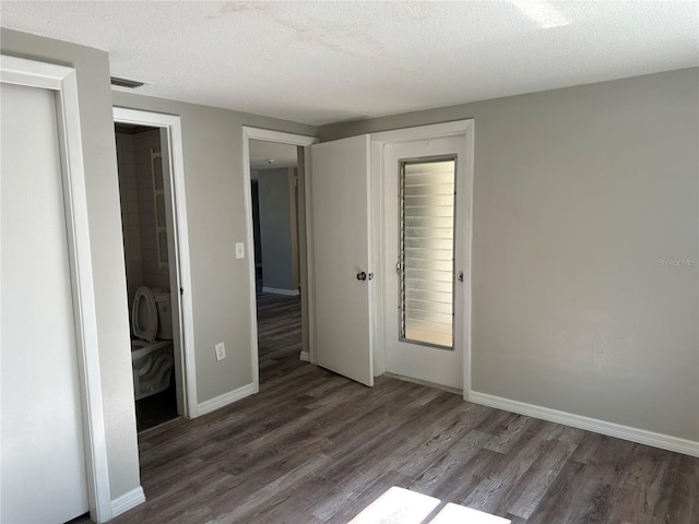 unfurnished bedroom with dark hardwood / wood-style floors and a textured ceiling