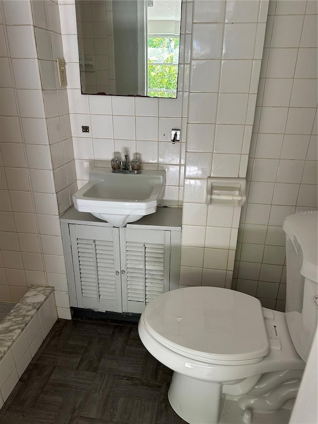 bathroom featuring tasteful backsplash, vanity, toilet, and tile walls